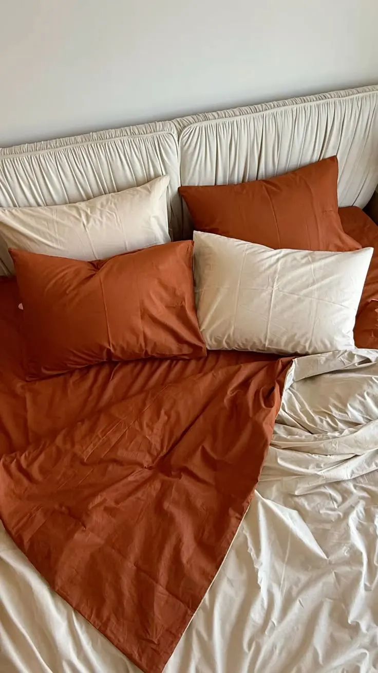 Lit avec draps terracotta et crème